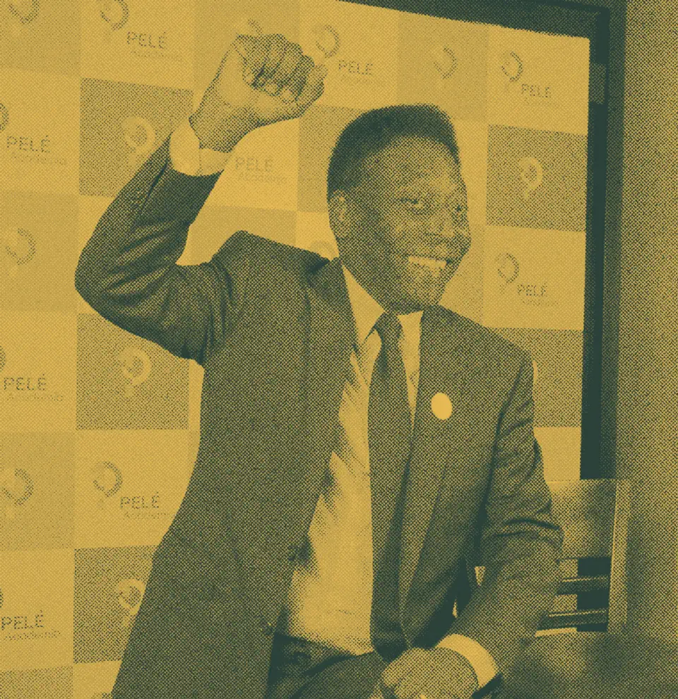 Pelé raising his fist in front of a backdrop with his name and logo.