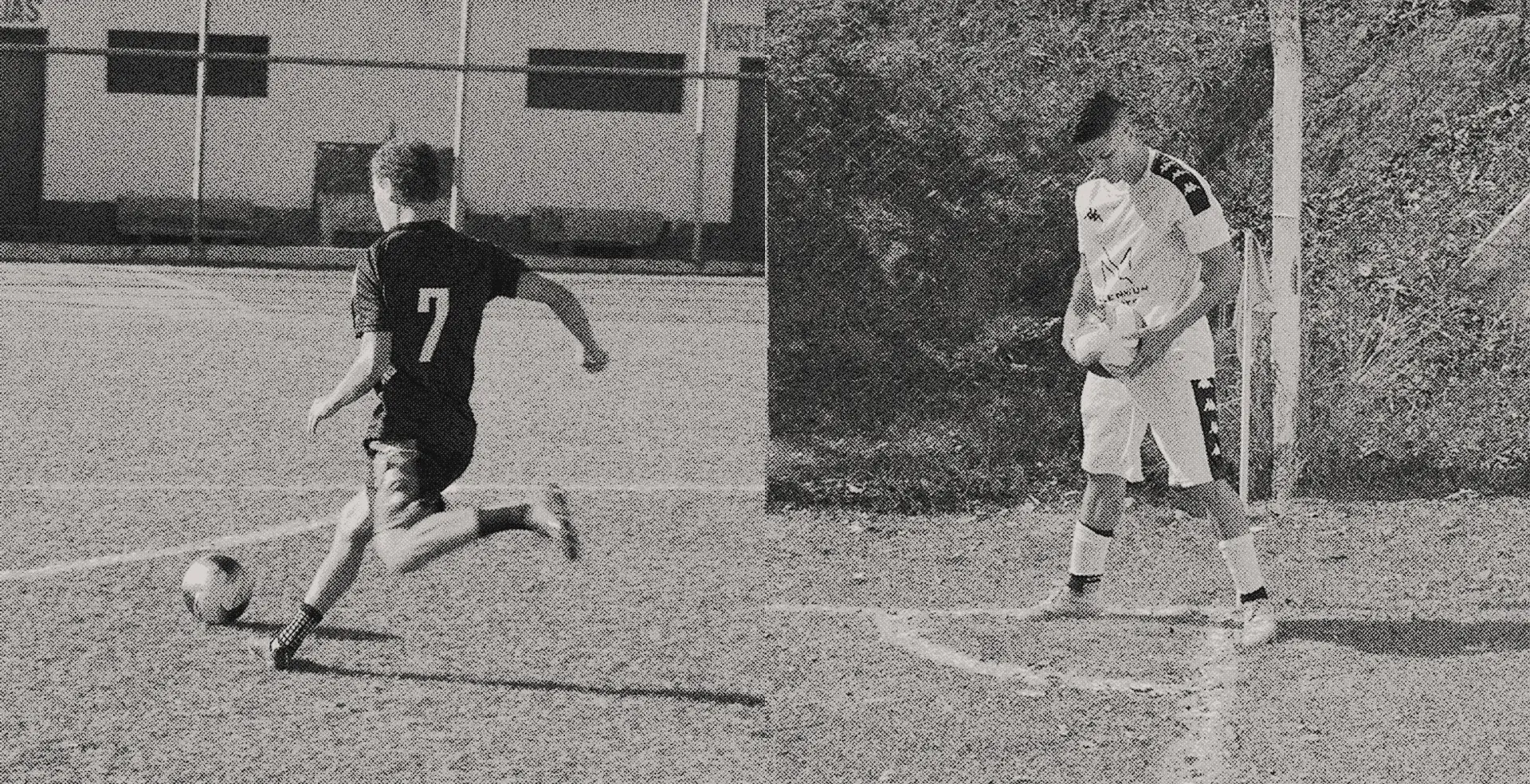 A black and white image of a soccer player with the number 7 on their jersey kicking a ball on a grassy field with a building in the background.