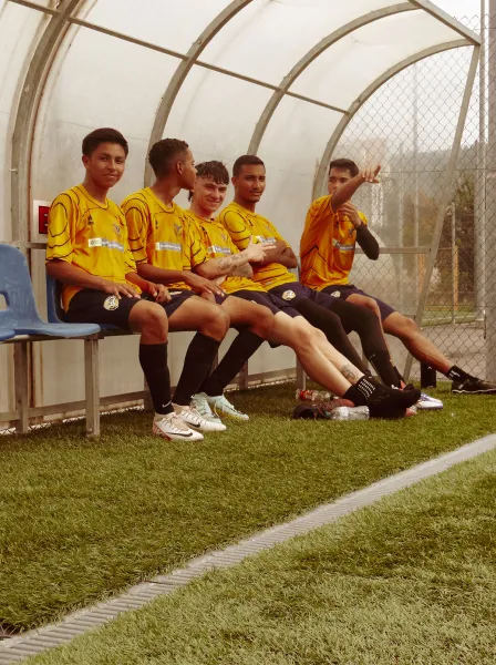 Jovens jogadores sentados no banco conversando.